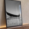 Barco de madeira solitário na areia da praia em maré baixa, fotografia preto e branco, quadro decorativo