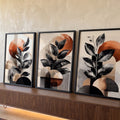 Três telas com folhas pretas sobre círculos terracota e formas geométricas em fundo bege, quadro decorativo