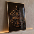 Medalha de São Bento em relevo bronze com cruz e inscrições sobre fundo marrom escuro, quadro decorativo