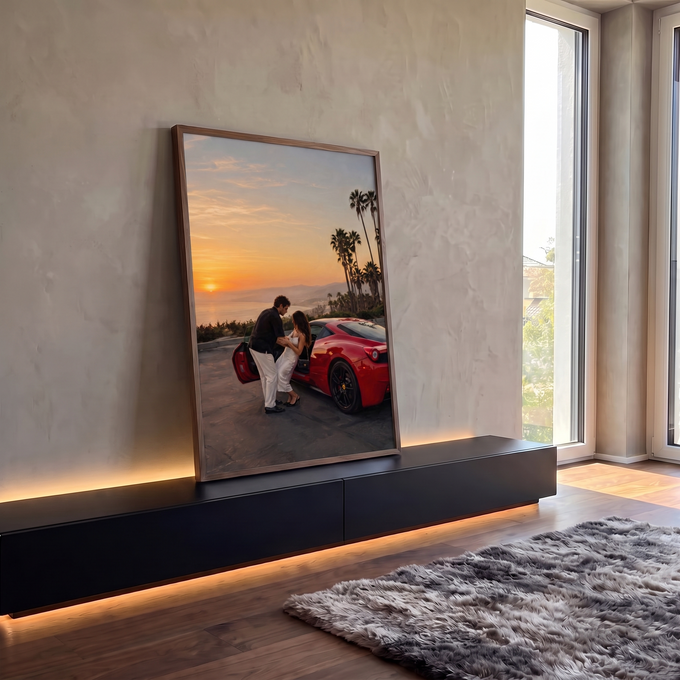 Casal abraçado ao lado de Ferrari vermelha ao pôr do sol com palmeiras e mar, quadro decorativo