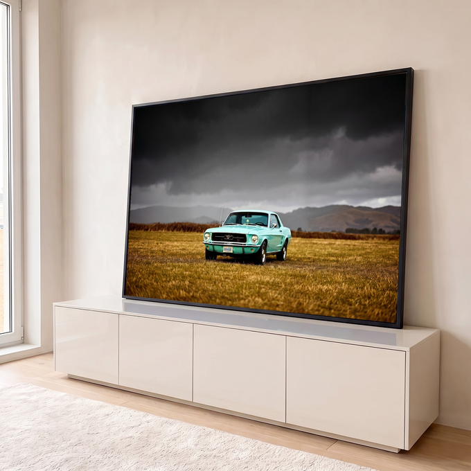 Mustang clássico turquesa em campo dourado sob céu cinza de tempestade e montanhas, quadro decorativo