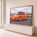 Porsche 911 laranja widebody com rodas raiadas e aerofólio em marina com barcos, quadro decorativo