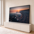Quadro Decorativo Grande Pôr do Praia para Sala Laranja | quadros decorativos para sala | pôr do sol dourado refletido na água com praia de pedras em primeiro plano | em Quadros para Sala | Porao dos Quadros