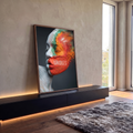 Rosto de mulher de perfil com olhos fechados e pó colorido laranja e verde se dispersando, quadro decorativo