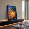 Onda do mar formando tubo com pôr do sol laranja e reflexos dourados na água, quadro decorativo