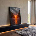 Estrada com linha amarela e sol em raios entre árvores sob céu nublado ao pôr do sol, quadro decorativo
