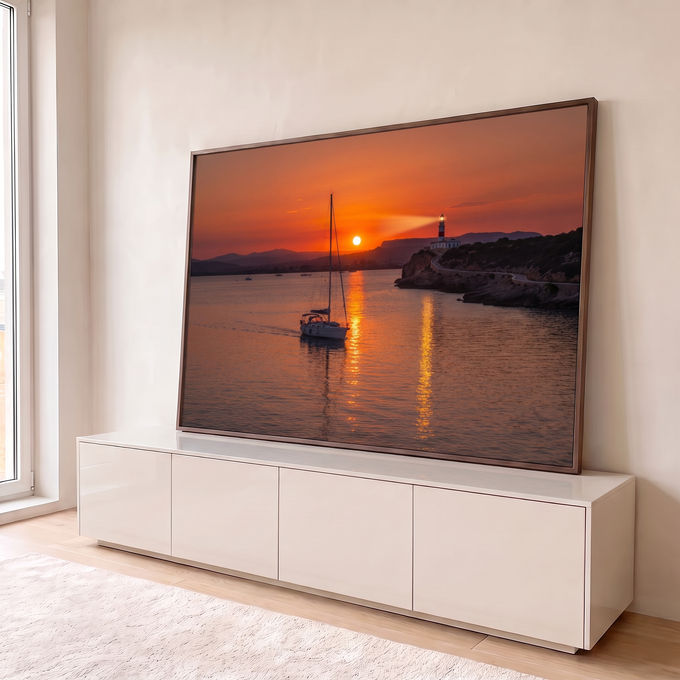 Quadro Decorativo Grande Veleiro e Farol Laranja para Sala | quadros decorativos para sala | veleiro navegando ao pôr do sol com farol aceso sobre penhasco rochoso | em Quadros para Sala | Porao dos Quadros