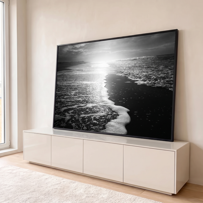 Fotografia em preto e branco de espuma do mar na areia escura com sol refletindo, quadro decorativo