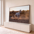 Cavalo branco galopando em picadeiro de areia, com poeira dourada ao pôr do sol, quadro decorativo