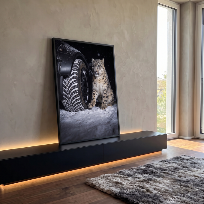 Leopardo-das-neves sentado ao lado de pneu de carro na neve em noite escura, quadro decorativo