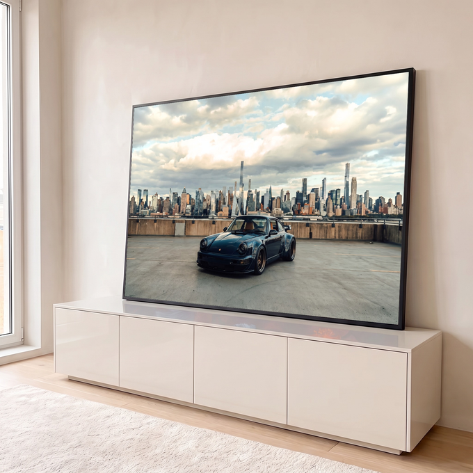 Porsche 911 azul-escuro em terraço com skyline de Nova York e céu nublado ao fundo, quadro decorativo