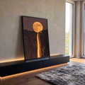 Lua cheia gigante sobre penhasco com silhueta humana e cachoeira dourada de fogo, quadro decorativo