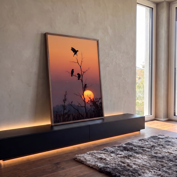 Quatro pássaros em silhueta num galho seco diante do sol se pondo em céu laranja, quadro decorativo
