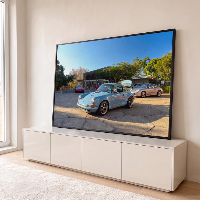 Porsche 911 clássico azul-claro em pátio de pedra com esportivos e árvores, efeito óleo, quadro decorativo