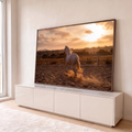 Cavalo branco trotando em picadeiro de areia ao pôr do sol, levantando poeira sob céu laranja, quadro decorativo