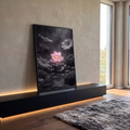 Flor de lótus rosa sobre pedras pretas molhadas e água, cenário zen em tons de cinza, quadro decorativo