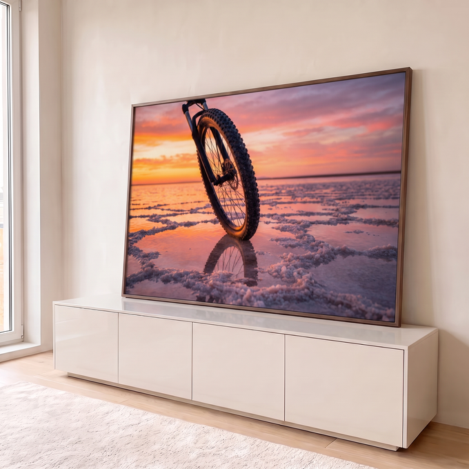 Quadro Decorativo Grande Bicicleta no Pôr do Sol para Sala | quadros decorativos para sala | roda de bicicleta em destaque sobre salar refletindo pôr do sol colorido | em Quadros para Sala | Porao dos Quadros