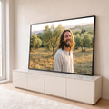 Jesus sorrindo de túnica bege em olival ao pôr do sol, luz dourada e colinas ao fundo, quadro decorativo
