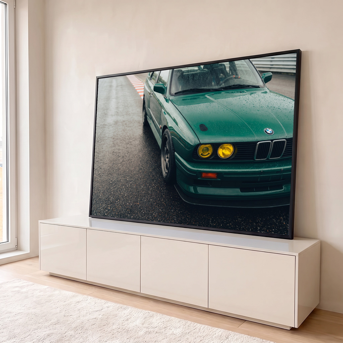 BMW M3 E30 verde com faróis amarelos e gotas de chuva parado na pista de corrida, quadro decorativo