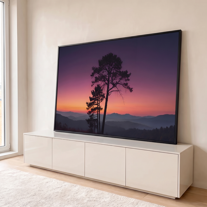 Pinheiros em silhueta sob céu roxo e laranja ao pôr do sol e montanhas enevoadas, quadro decorativo