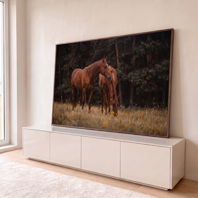 Dois cavalos castanhos, um pastando, em campo dourado com flores amarelas e mata escura, quadro decorativo
