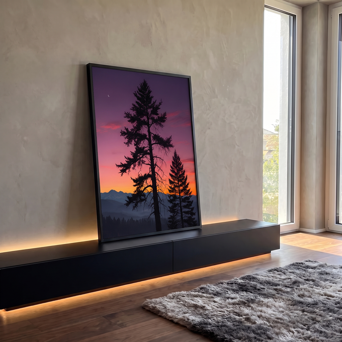 Silhuetas de pinheiros contra céu roxo e laranja, montanhas enevoadas e lua crescente, quadro decorativo