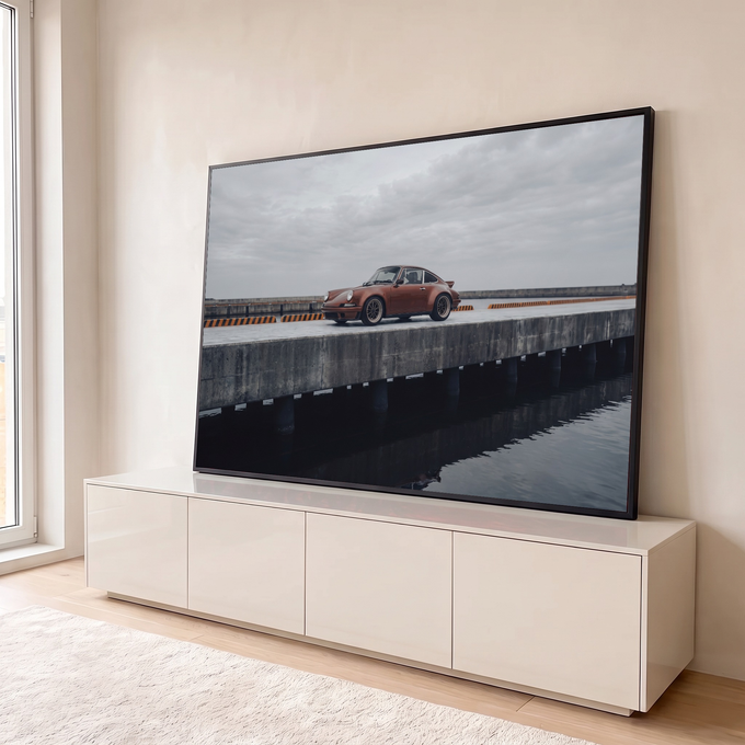 Porsche 911 clássico cor cobre em píer de concreto sobre o mar sob céu cinza, quadro decorativo