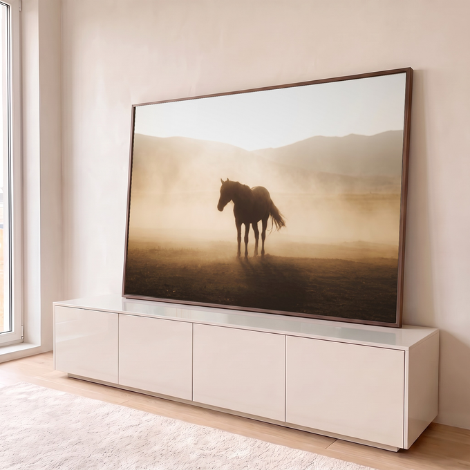 Cavalo solitário em contraluz na poeira dourada do campo com montanhas ao fundo, quadro decorativo