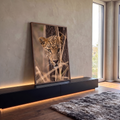 Leopardo de olhos verdes espreitando atrás de tronco entre capim seco, fotografia, quadro decorativo