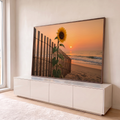 Quadro Decorativo Grande Girassol Cerca para Sala Amarelo | quadros decorativos para sala | girassol amarelo sobre cerca de madeira com praia e pôr do sol ao fundo | em Quadros para Sala | Porao dos Quadros