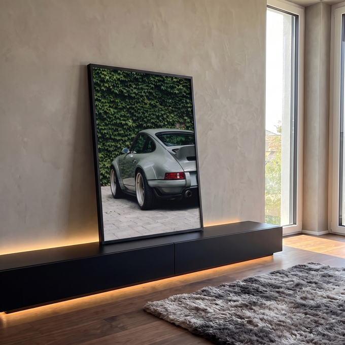 Porsche 911 clássico cinza visto de trás diante de muro de hera verde sobre paralelepípedo, quadro decorativo