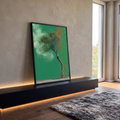 Árvore de tronco retorcido com copa se desfazendo em fumaça verde diante de parede verde, quadro decorativo