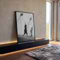 Menino descalço correndo com pipa e sombra projetada em parede rachada, preto e branco, quadro decorativo
