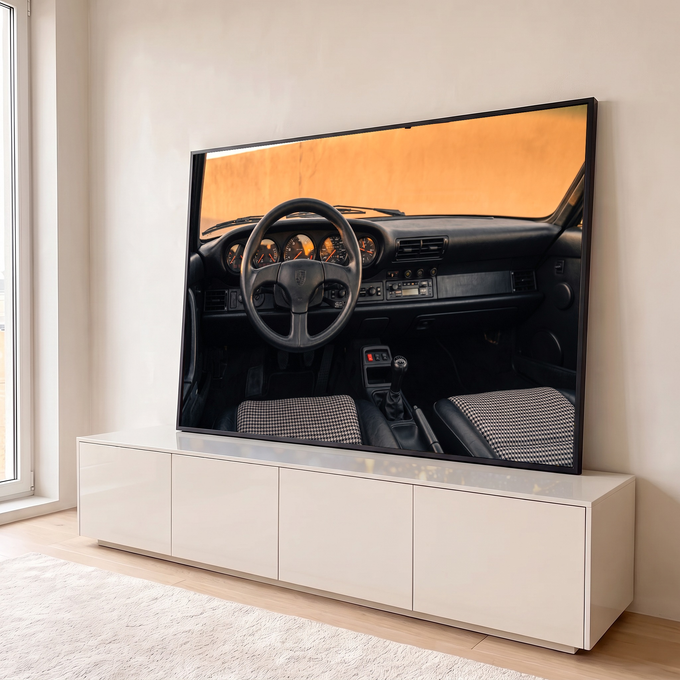 Interior de Porsche 911 clássico com volante preto, painel laranja e bancos pied-de-poule, quadro decorativo