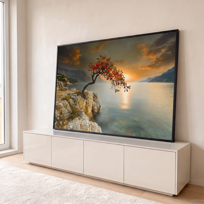 Árvore de frutos vermelhos sobre rochedo à beira-mar com pôr do sol laranja e montanhas, quadro decorativo
