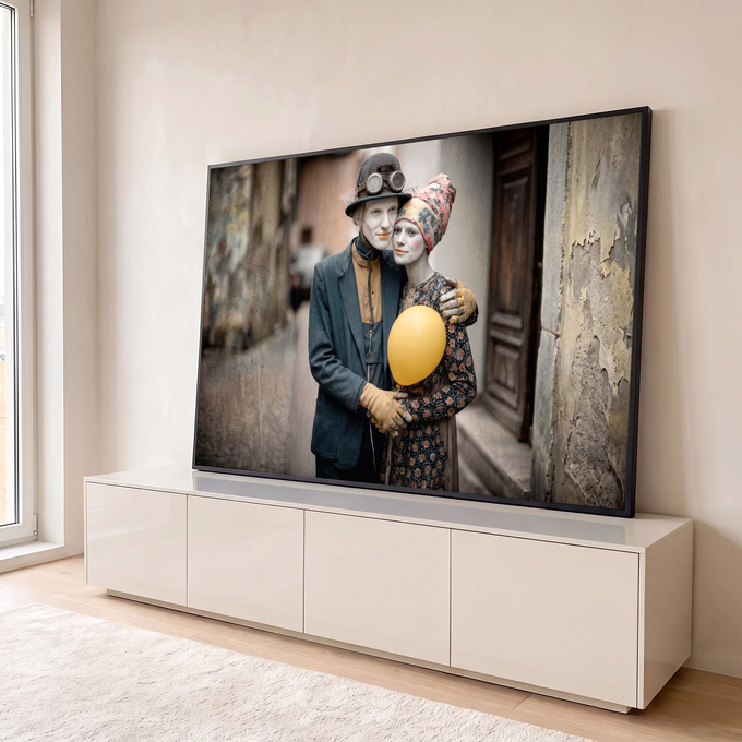 Quadro Decorativo Grande Casal de Mimos para Sala Cinza | quadros decorativos para sala | casal com rosto pintado de branco abraçado segurando balão amarelo em beco antigo | em Quadros para Sala | Porao dos Quadros