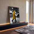 Homem de capa amarela atravessando rua chuvosa da cidade em foto preto e branco, quadro decorativo