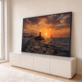 Farol sobre rochas ao pôr do sol com vila branca, veleiros e barcos de pesca no mar, quadro decorativo