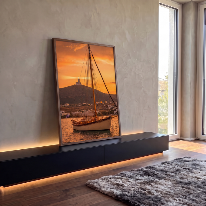 Veleiro ancorado ao pôr do sol laranja com farol na colina e vila grega branca, quadro decorativo