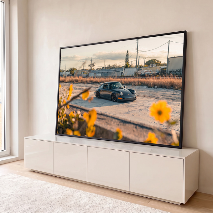 Porsche 911 clássico rebaixado ao entardecer com flores amarelas em primeiro plano, quadro decorativo