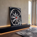 Close de roda esportiva cromada com raios brilhantes e calota vermelha, quadro decorativo