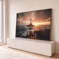 Quadro Decorativo Grande Farol Mar para Sala Laranja | quadros decorativos para sala | farol branco em rochas no mar com céu alaranjado ao pôr do sol | em Quadros para Sala | Porao dos Quadros