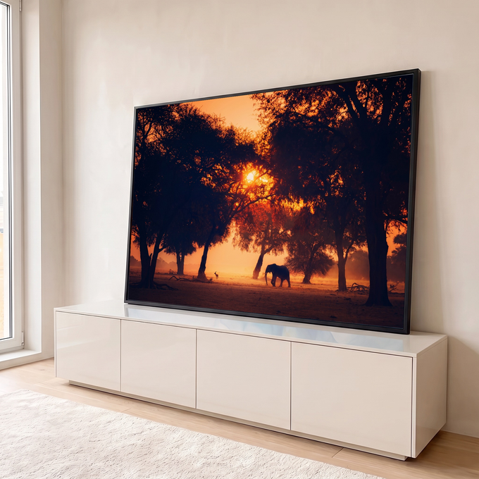 Elefante e gazela em silhueta entre árvores com sol laranja atravessando a mata, quadro decorativo