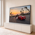 Quadro Decorativo Grande Casal e Carro para Sala Vermelho | quadros decorativos para sala | casal se abraçando ao lado de carro esportivo vermelho em pôr do sol litorâneo com palmeiras | em Quadros para Sala | Porao dos Quadros