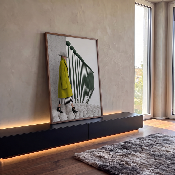 Mulher de casaco verde e chapéu cônico diante de postes refletidos na água em neblina, quadro decorativo