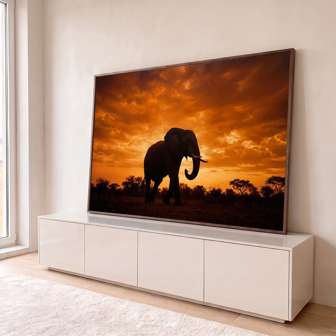 Silhueta de elefante africano com presas sob céu laranja de pôr do sol na savana, quadro decorativo