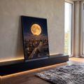 Quadro Decorativo Grande Homem de Túnica para Sala Dourado | quadros decorativos para sala | homem de túnica branca sentado em telhado observando lua dourada gigante sobre cidade noturna | em Quadros para Sala | Porao dos Quadros