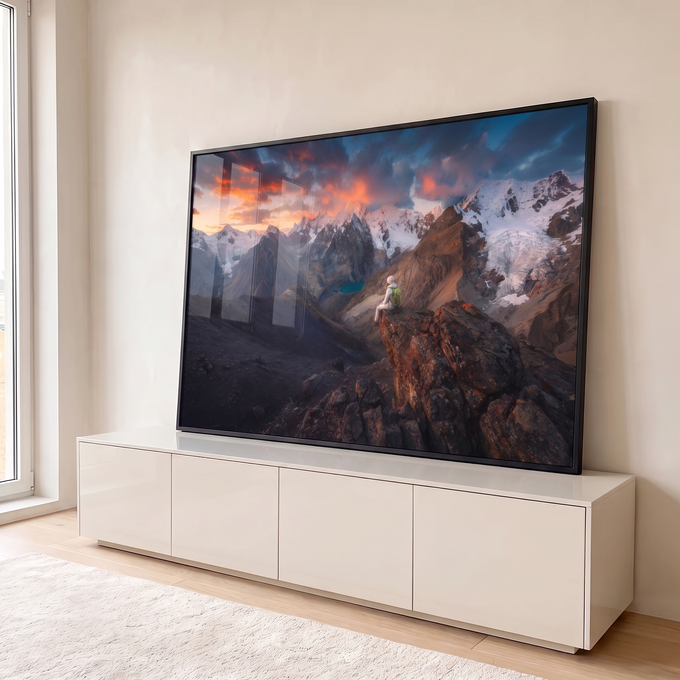 Quadro Decorativo Grande Viajante Contemplando para Sala | quadros decorativos para sala | pessoa sentada em penhasco observando cordilheira nevada e pôr do sol alaranjado | em Quadros para Sala | Porao dos Quadros