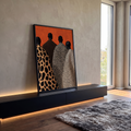 Quadro Decorativo Figuras de Costas com Mantos de Animal | quadros decorativos para sala | quatro silhuetas de costas com mantos de estampa animal print sobre fundo laranja | em Quadros para Sala | Porao dos Quadros