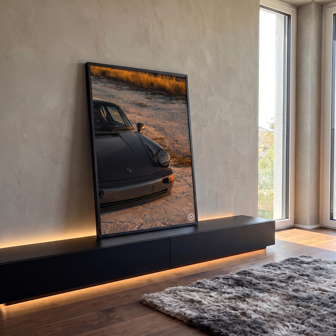 Quadro Decorativo Grande Carro Esportivo Preto para Sala | quadros decorativos para sala | carro esportivo cinza escuro com farol redondo em cenário de areia ao entardecer | em Quadros para Sala | Porao dos Quadros